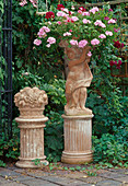 Impruneta-Terracotta: Mädchenfigur, Früchtekorb auf Säulen, Schale bepflanzt mit Pelargonium peltatum (Hängende Geranien)