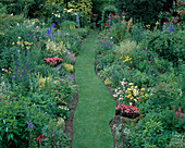 Red GABLES, WORCESTERSHIRE: HERBACEOUS BORDERS AND GRASS Walk with URNS PLANTED with PELARGONIUM 'Red GABLES'