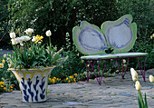Schmetterlingsbank neben Keramiktopf, bepflanzt mit weißen Tulpen