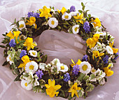 Plate wreath with flowers of daffodils, daffodils, grape hyacinths, and box