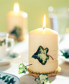 Kerze verziert mit Efeublättern und Golddraht