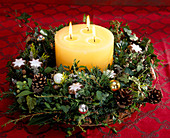 Adventsgesteck aus Zweigen, Zapfen und Kerze