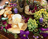 Style with cheese, baguette, grapes, clematis flowers