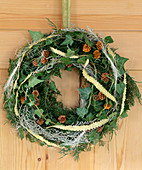 Door wreath made of fir branches, Hedera (ivy vines), cones, Artemisia (wormwood branch)