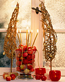 Glass vase filled with ornamental apples (Malus), trees of willow branches