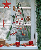 Christmas decorated window with apples, stars and garland of twigs