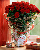 Bouquet with red roses, decorated with clematis vines