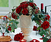 Vase with flower arrangement as table decoration made of red roses