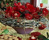 Schale mit Kranz aus Stöcken, rote Rosen, Hagebuttenzweige, Skimmia (Skimmie)