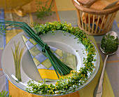 Herb plate decoration: semicircle made of wire wrapped with dill, chive bundle on napkin