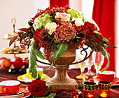 Iron amphora with autumnal arrangement of carnations and hydrangeas