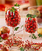 Rose rosehips in wine glasses and as a wreath, hedera ivy, malus apples