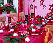 Festive table decoration with poinsettias and baubles