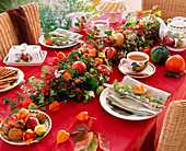 Tischgirlande aus Rosa (Hagebutten), Clematis (Waldrebe), Hedera (Efeu), Malus (Äpfel)