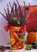 Calluna vulgaris (budding heather) in pot with napkin decoration, Cucurbita
