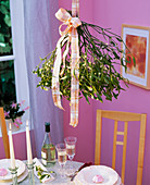 Viscum album (mistletoe) with ribbon hung over table
