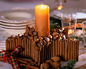Cinnamon star: Cinnamon sticks, Corylus (hazelnuts, Juglans (walnuts), candle with gold decoration