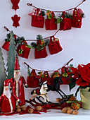 Kleine rote Filztaschen an Schnüre gebunden als Adventskalender, Weihnachtsmänner