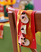 Malus (apple slices), sultanas threaded through, ribbon, cloth with pins