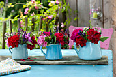 Small bouquets in jugs on wooden board