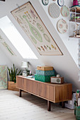 Retro sideboard below botanical illustration on sloping ceiling