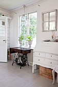 Old sewing machine base and white-painted bureau