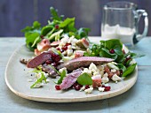 An oriental purslane salad with rocket, lamb fillets and sheep's cheese in chili sesame dressing
