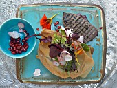 Algerian-style tuna fillets with puff pastry, pomegranates and a flower salad