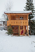 Alpine-style wooden cabin in snowy garden