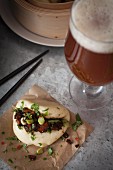Vegan steamed bao bun filled with smoked tofu and chestnut mushrooms marinated in soy, sesame oil, chilli sauce and garlic, topped with sliced spring onions, corriander and red chilli