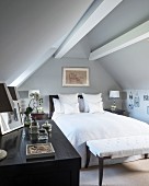Double bed and bench below roof beams