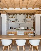 Dining table and modern shell chairs in Mediterranean kitchen
