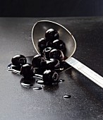 Black olives on a spoon