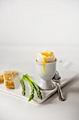 A soft-boiled egg with asparagus and toast soldiers