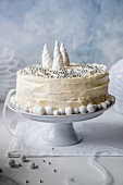 A Christmas cake with white chocolate icing, decorated with silver beads