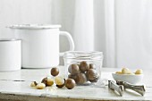 Macadamia nuts in a glass jar and a nutcracker on a rustic kitchen table