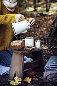 Picknick im Wald, Frau schenkt eine Tasse Tee ein