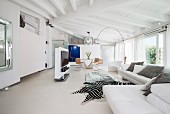 White couch, arc lamp and zebra-skin rug in elegant living area
