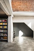 Graue Wandnische in umgebautem Loft mit Fahrrad und Bücherregal