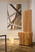 Moderner Thronstuhl aus Holz vor Kunst mit Schnüren