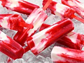 Raspberry and daiquiri cheesecake ice lollies on a bed of ice cubes