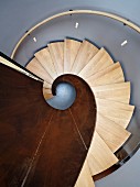 Blick von oben auf eine Wendeltreppe aus Metall und Holz