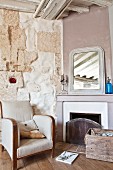 Armchair next to open fireplace in restored country house