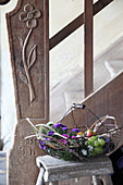 Basket of asters, grapes, pears and damsons for the harvest festival on stool