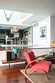 Red armchair in living room with dining area on raised level