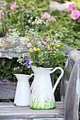 Wild flowers in painted jug on vintage garden bench