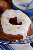 A doughnut with lemon icing and candied orange pieces