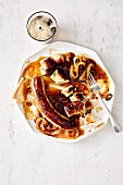 Coarsely-ground sausage with a malt beer and onion sauce (soul food)