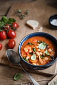 Tuscan ribollita soup with beans, tomatoes, kale and basil in a bowl
