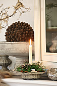 Rustic wreath and lit candle in small basket